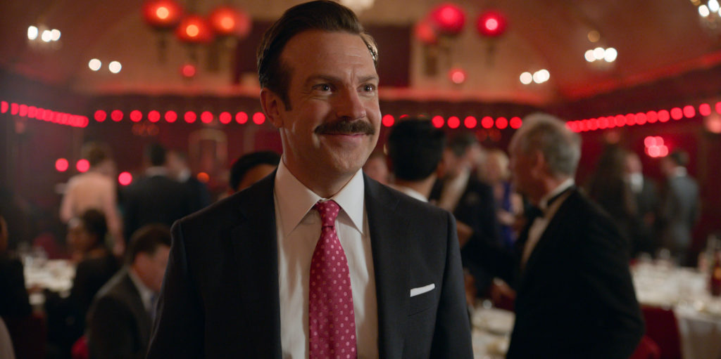 Photo from Ted Lasso, with Ted wearing a suit and tie at a fancy party